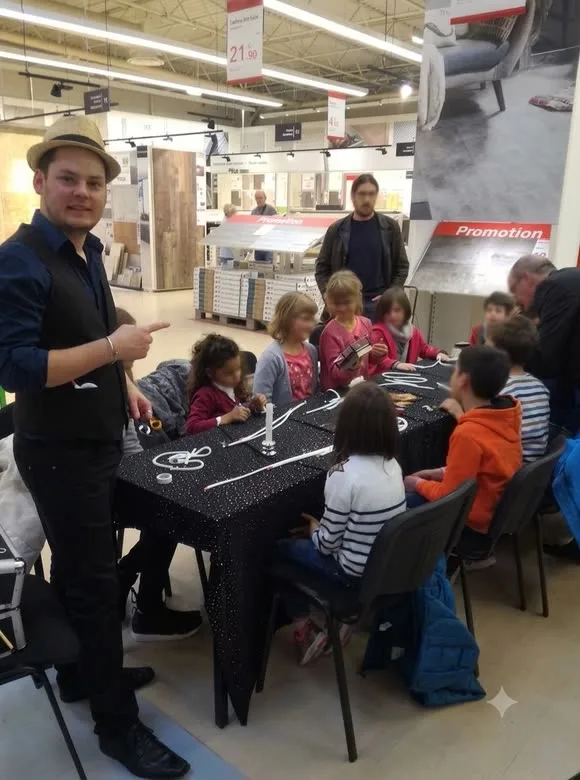 Des enfants attablés nouent des cordes autour de Jérôme lors d’un atelier