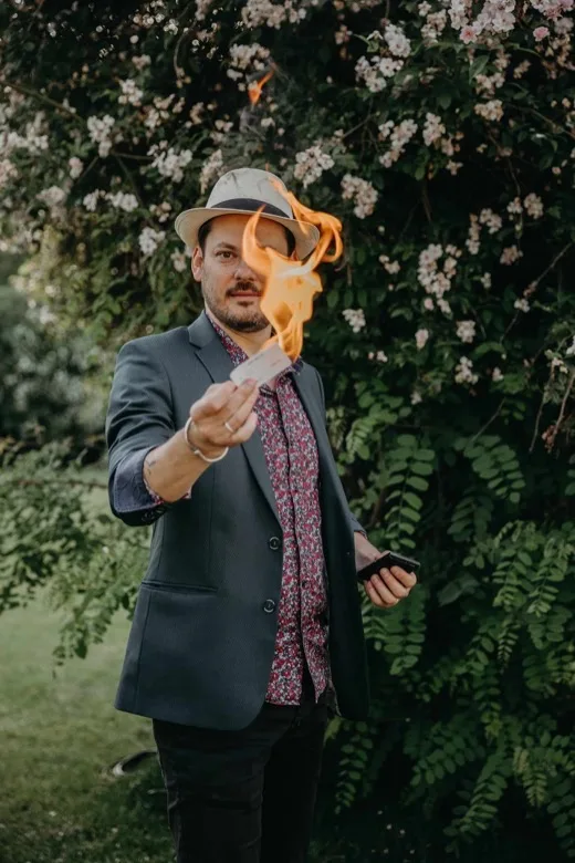 Jérôme tend une carte enflammée dans un jardin fleuri